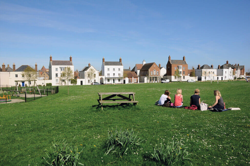 Family sat on grass at Holmead Walk, Poundbury